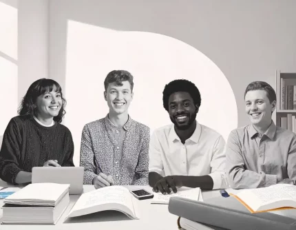 Schwarz weiß Foto von verschiedenen lächelnden Menschen, die in einem friedlichen Büro mit neuropsychologischen Büchern und Hilfsmitteln für die Barrierefreiheit an einem inklusiven Webdesign arbeiten